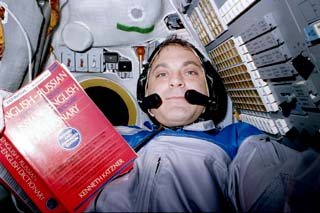 Mission Specialist Wolf reading a Russian-English dictionary.